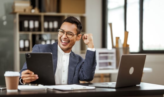 Middle-aged Asian businessman in formal suit working diligently at his desk.